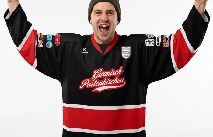 A player celebrating arms-up in the KAPO jersey